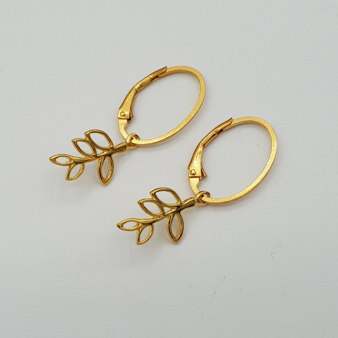 Goud vergulde oorbellen met blad hanger