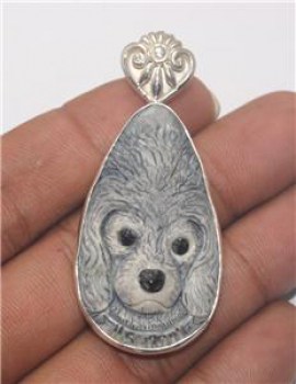 Zilveren hanger met gezicht hond uit been gesneden