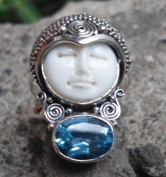 Zilveren ring met gezicht uit been en blauw Topaas